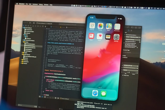 מסך מחשב המציג סימולטור iPhone לצד קוד Swift בסביבת פיתוח Xcode